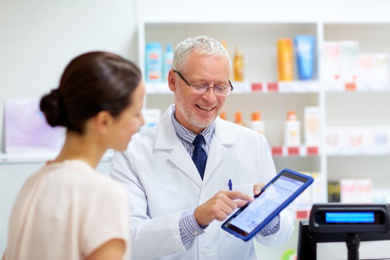  senior apothecary and female customer with digital prescription on tablet pc computer screen at pharmacy